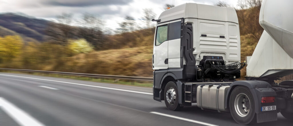 Camion de transport routier engagé sur une route pour un transfert industriel